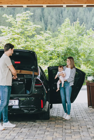 Familie packt Gepäck am Hotel Tyrol aus