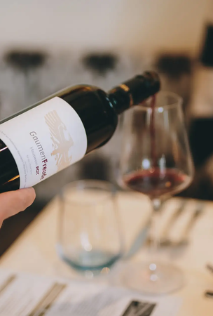 Rotwein wird ins Glas eingeschenkt