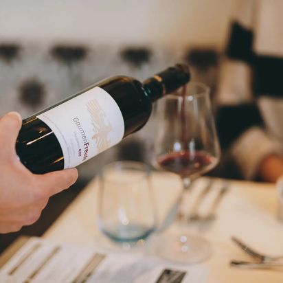 Rotwein wird ins Glas eingeschenkt