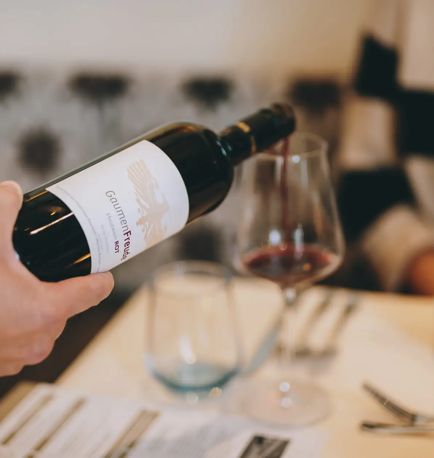 Rotwein wird ins Glas eingeschenkt