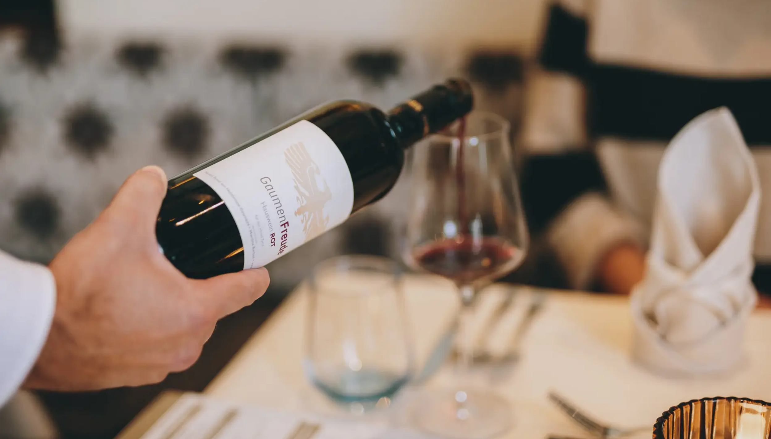 Rotwein wird ins Glas eingeschenkt