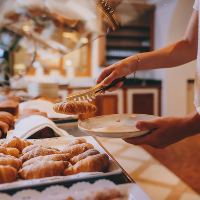 Frühstücksbuffet im Hotel Tyrol am Haldensee, Croissant wird entnommen