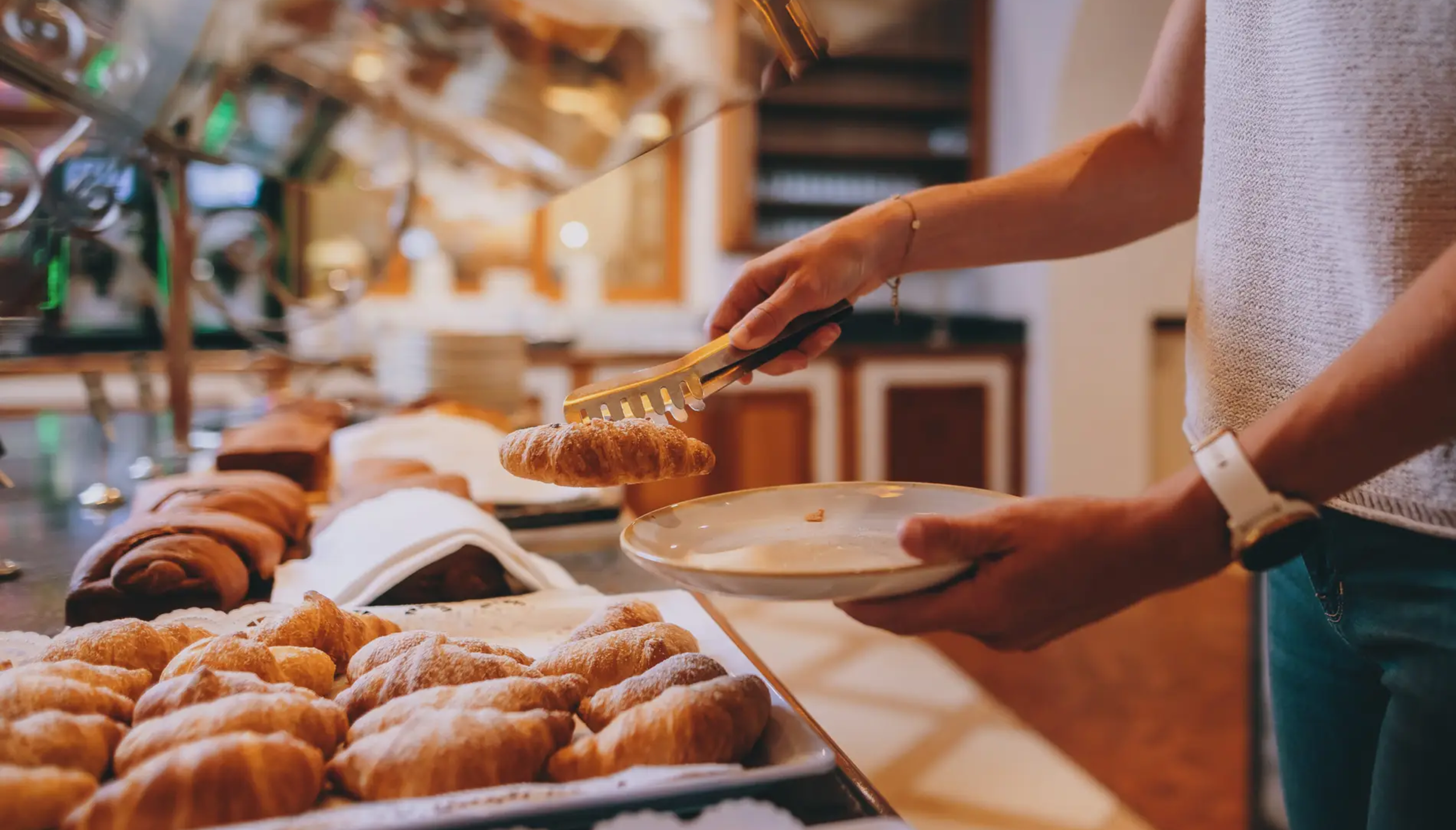 Frühstücksbuffet im Hotel Tyrol am Haldensee, Croissant wird entnommen