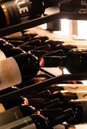 Weinregal mit verschiedenen Rotweinen