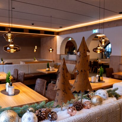 Gemütlicher Hotelrestaurantbereich mit Holztischen und Weihnachtsdekoration