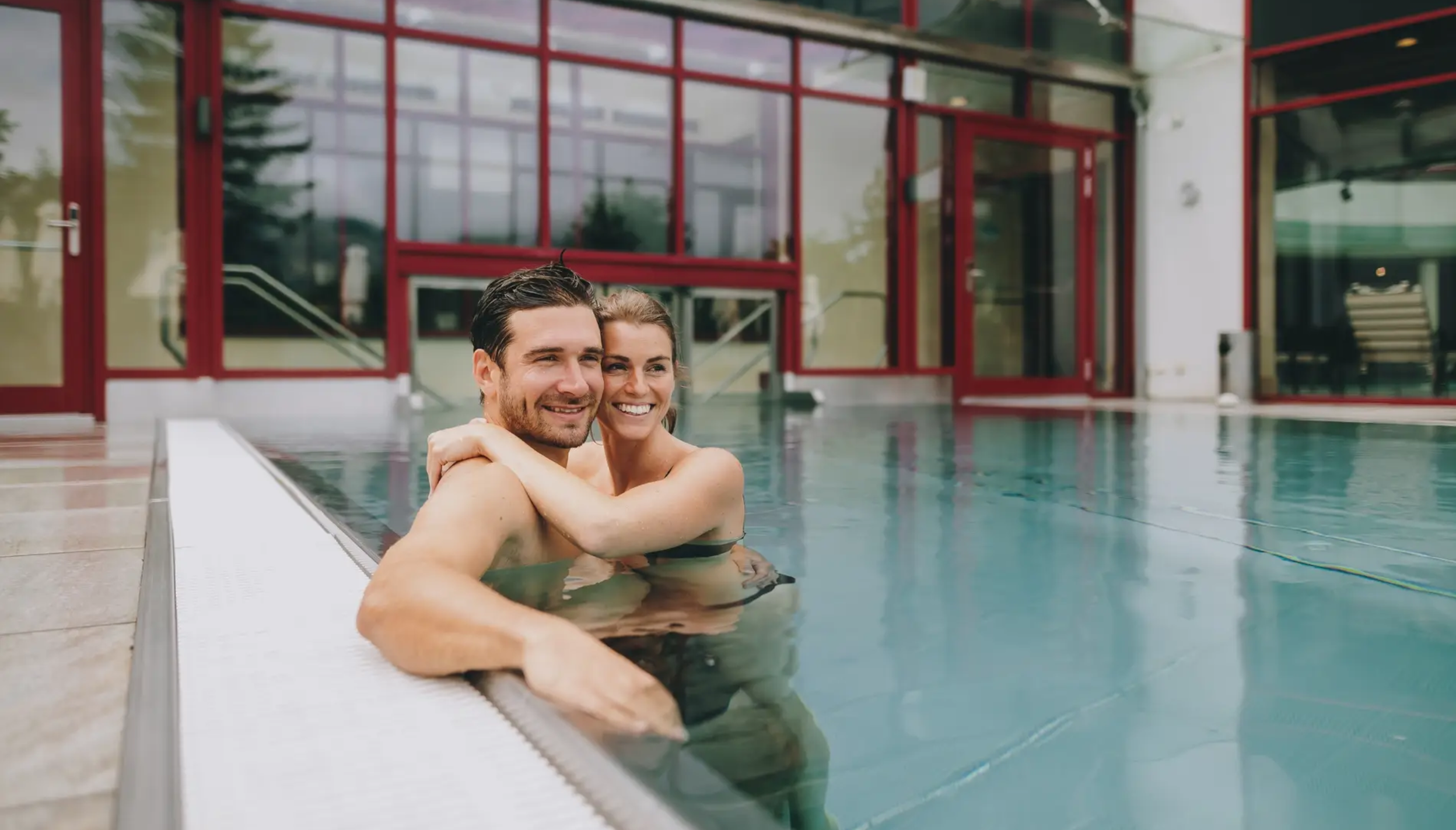 Paar umarmt sich im Hotel-Pool