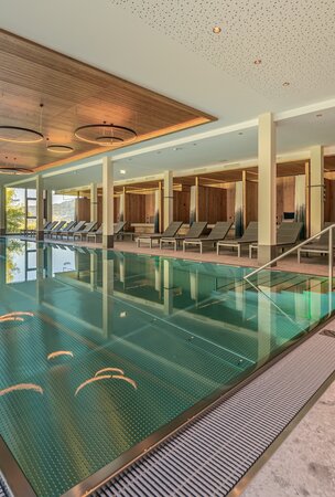 Hotel Tyrol Innenpool mit Liegen und Ausblick