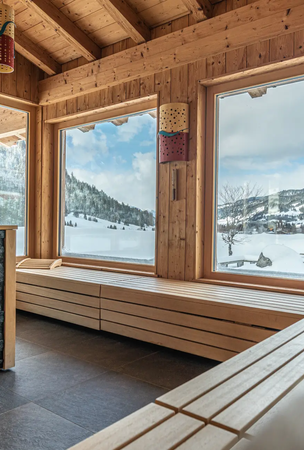 Holzsauna mit Blick auf verschneite Berge im Hotel Tyrol am Haldensee