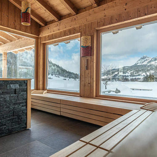 Holzsauna mit Blick auf verschneite Berge im Hotel Tyrol am Haldensee