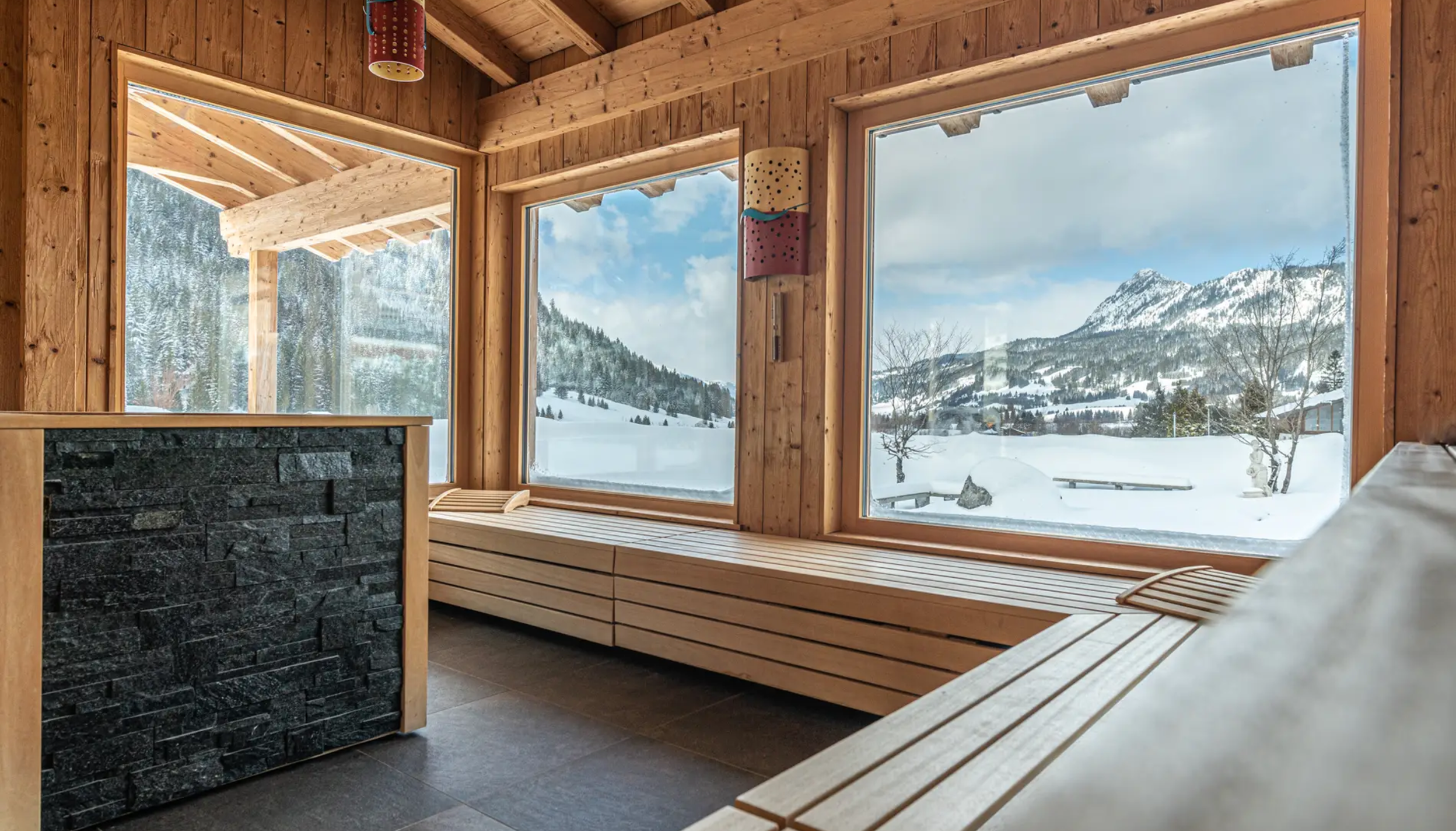 Holzsauna mit Blick auf verschneite Berge im Hotel Tyrol am Haldensee