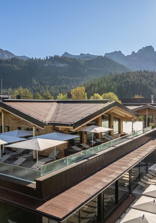 Hotel Tyrol am Haldensee, Dachterrasse mit Liegen und Sonnenschirmen, Bergkulisse