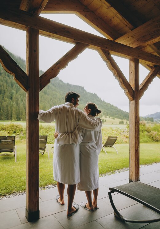 Paar in Bademänteln mit Blick auf die Berge
