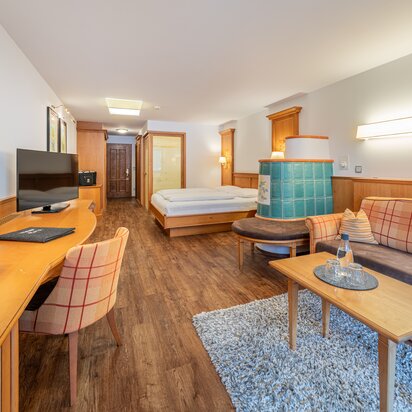 Hotel Tyrol Zimmer mit Bett, Sofa und Tisch