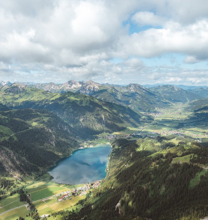 Haldensee in the Tannheimer Valley, surrounded by mountains and clouds
